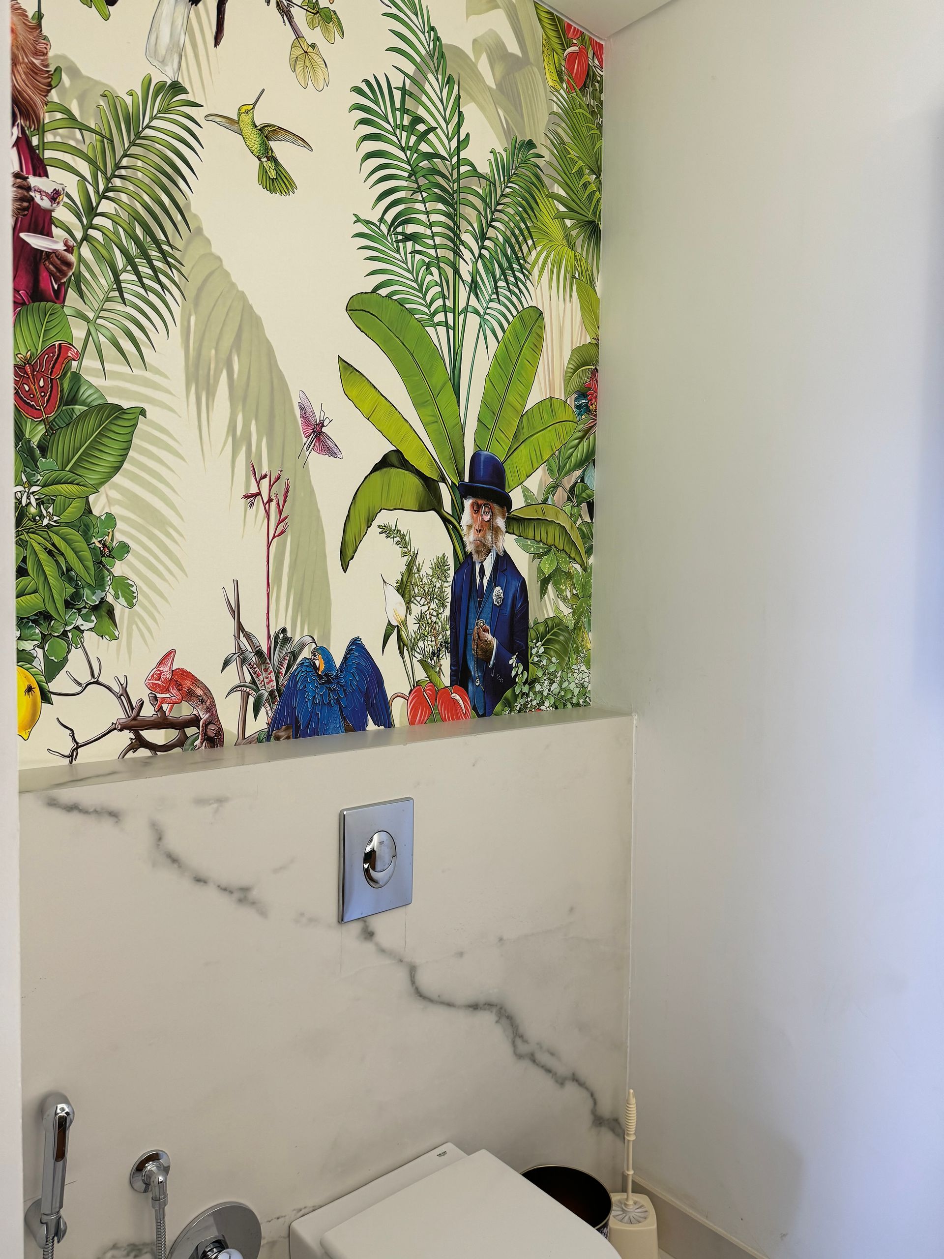 Toilet with floral wallpaper, marble accents, and a figure in a suit within the design.