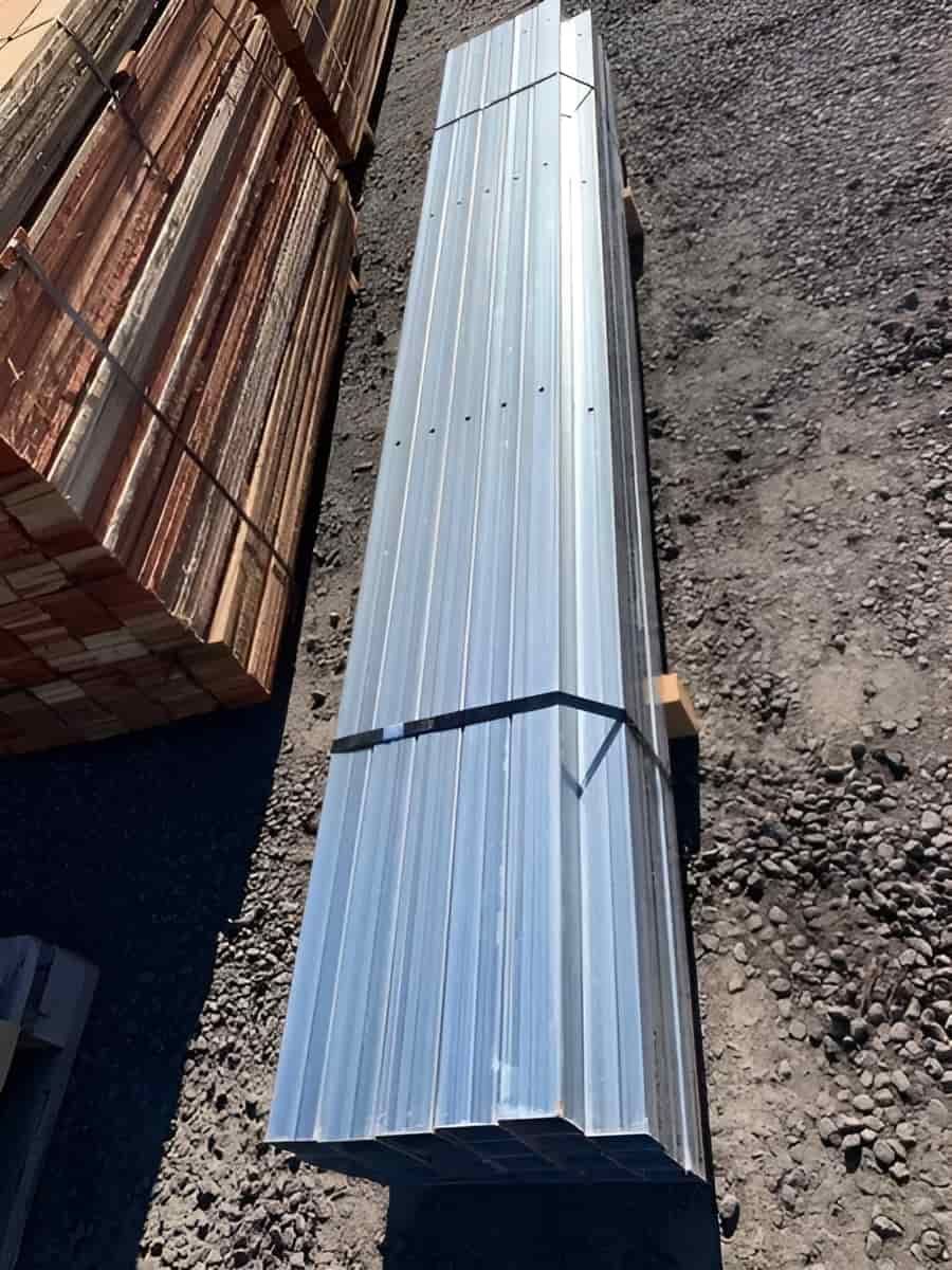 A Stack Of Metal Pipes Sitting On Top Of A Pile Of Gravel — Perry's Timber & Fencing In Dapto, NSW