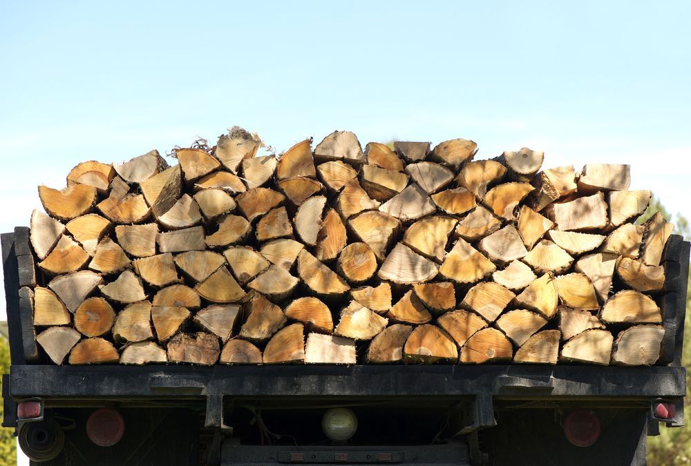 A Pile of Logs is Sitting on the Back of a Truck — Perry's Timber & Fencing In Albion Park, NSW