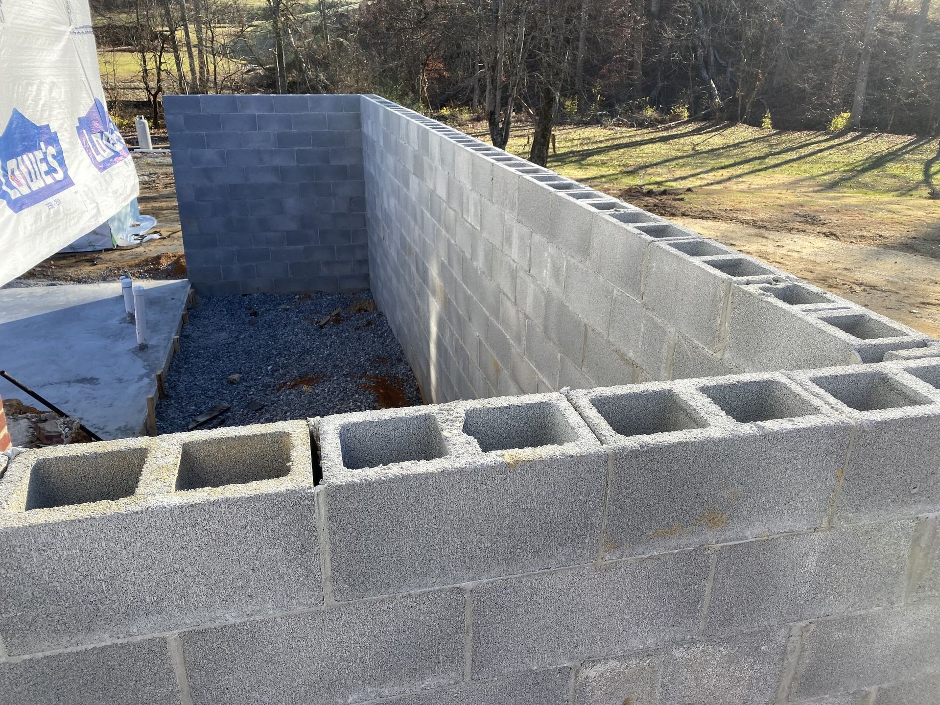 Concrete block foundation walls under construction outdoors.