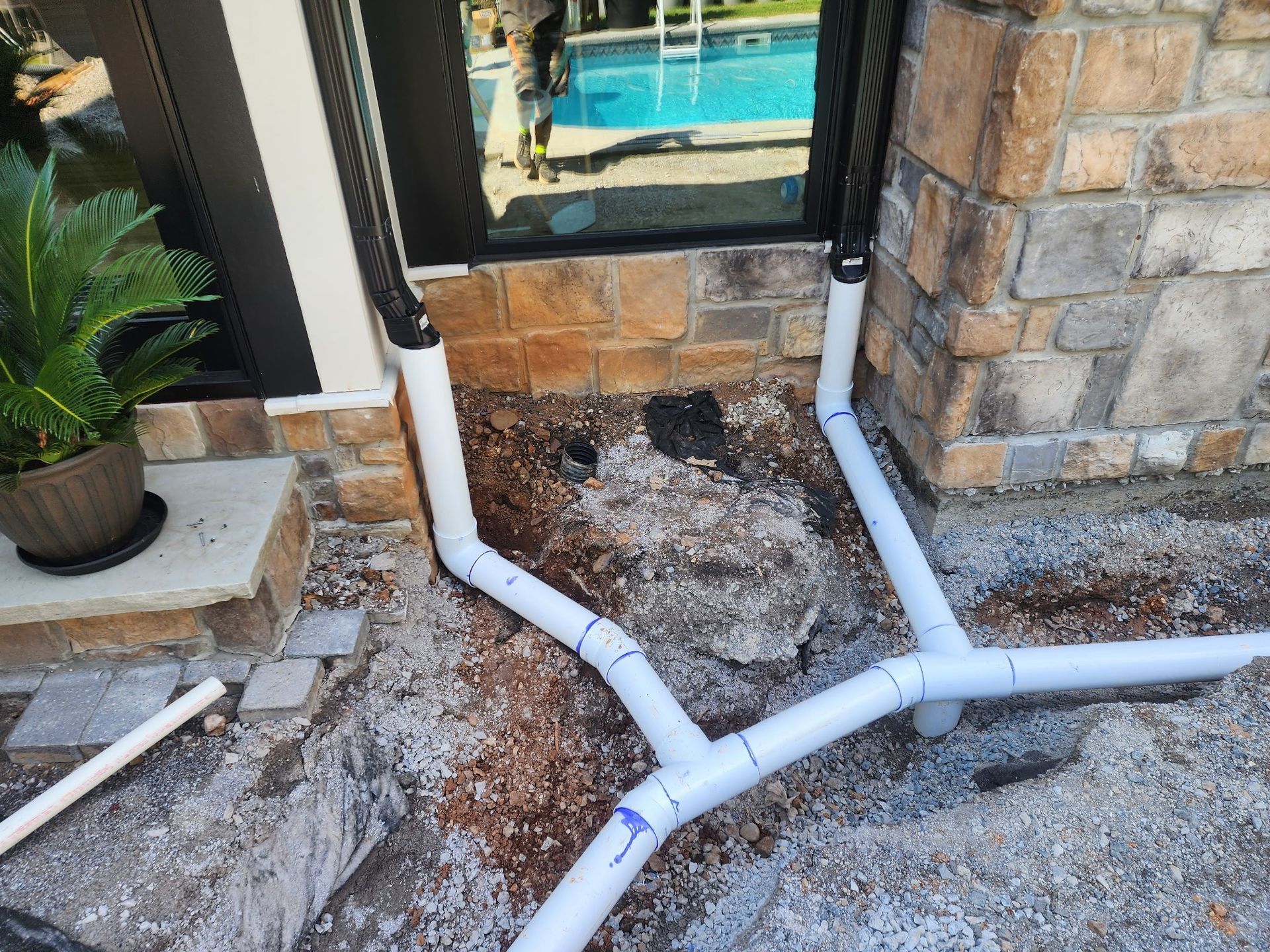 Coiled black corrugated drainage pipe bound with green straps.