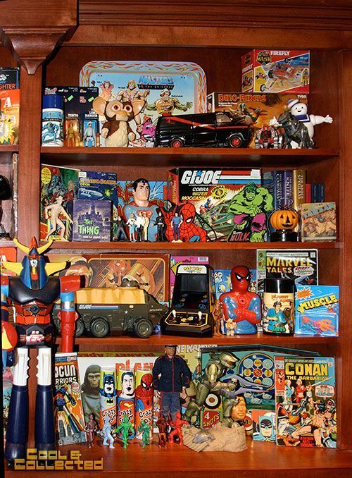 Shelf filled with vintage toys, including G.I. Joe, Spider-Man, and Voltron figures, plus a lunchbox.