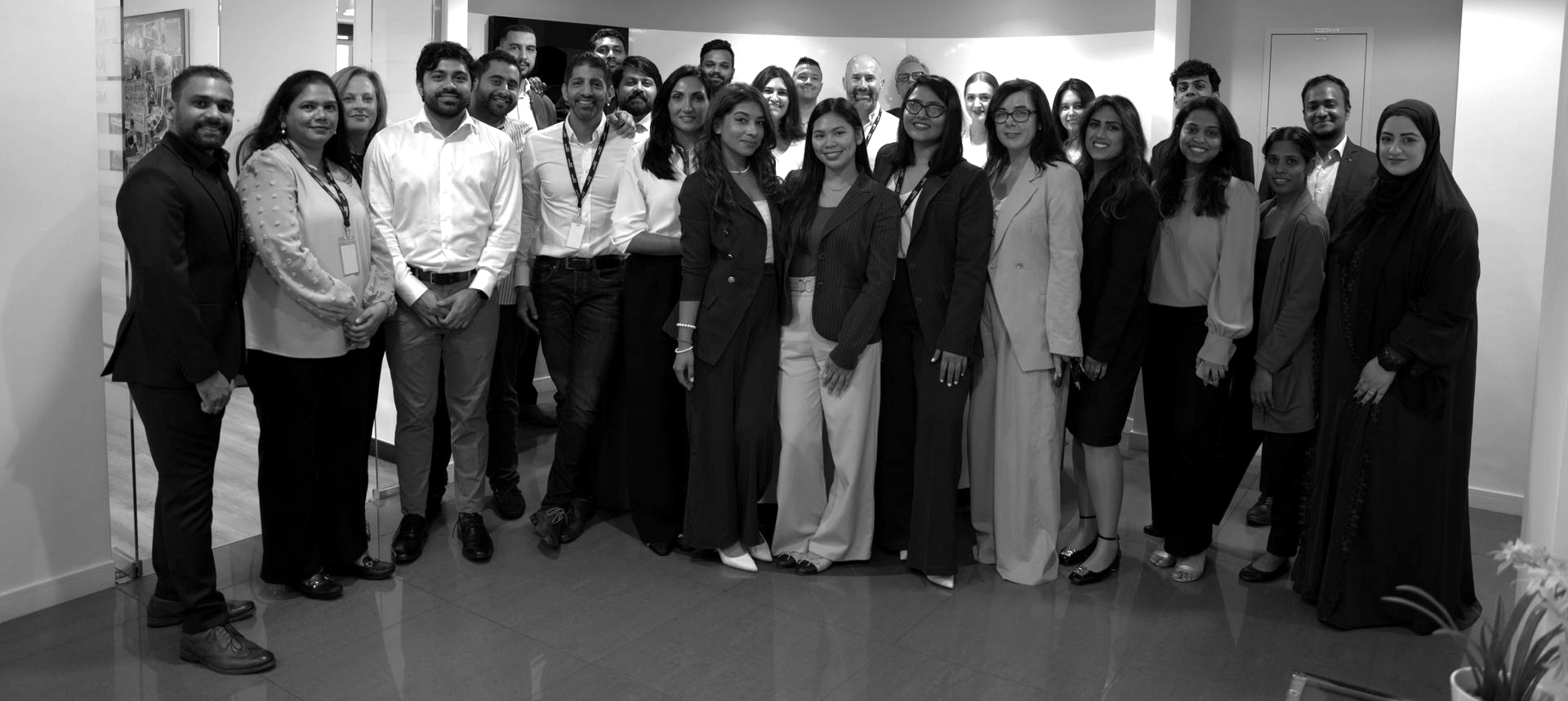 A group of people are sitting around a table with laptops.