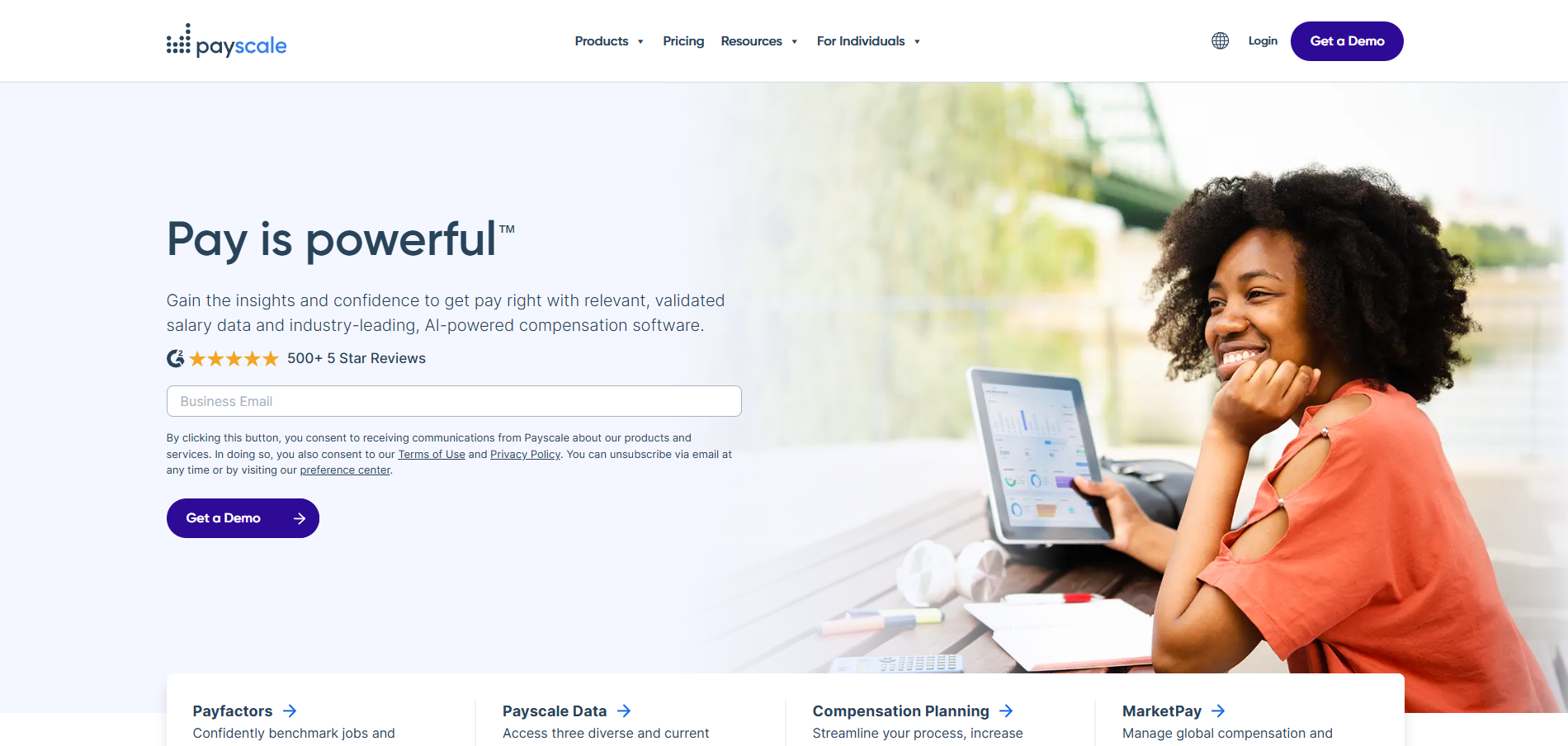 A woman is sitting at a table using a laptop computer.