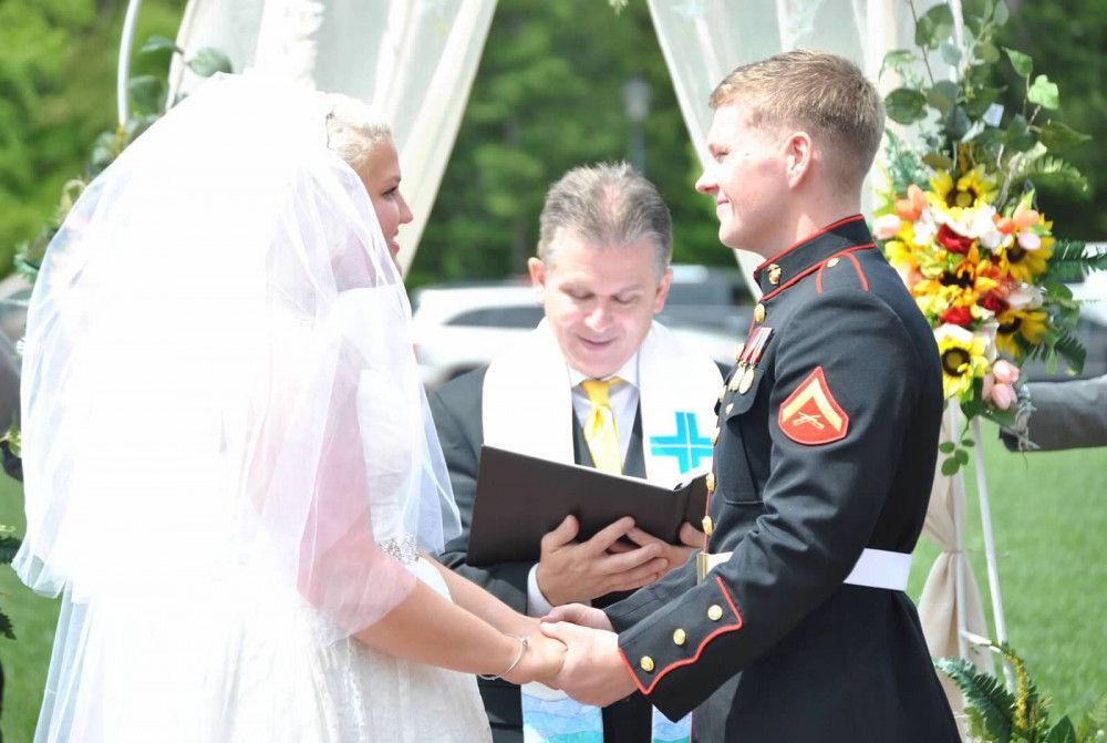 A bride and groom are holding hands during their wedding ceremony