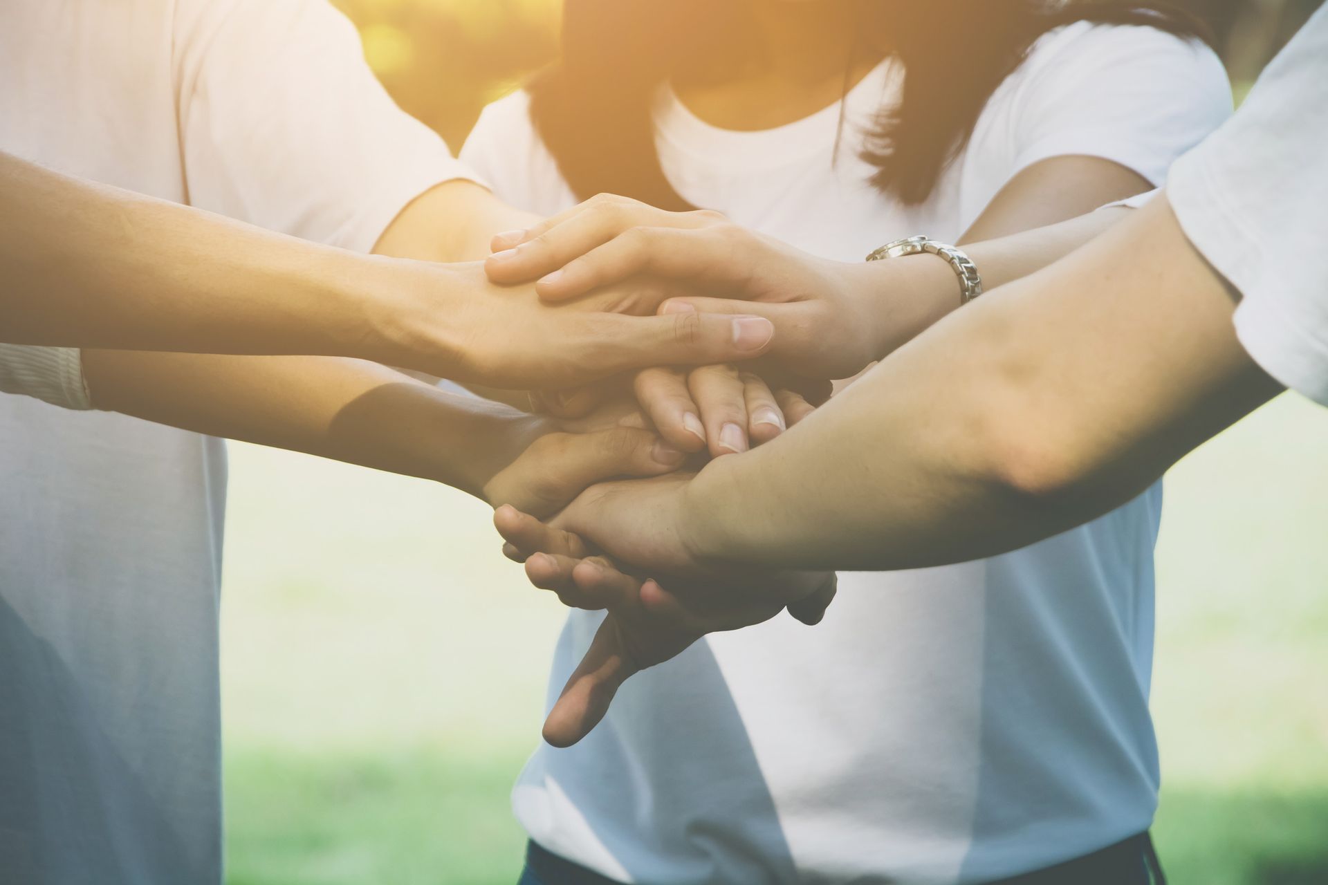 Hands of several people stacked together, symbolising teamwork.