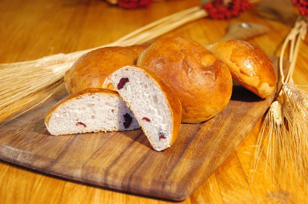 A bunch of bread is sitting on a wooden cutting board.