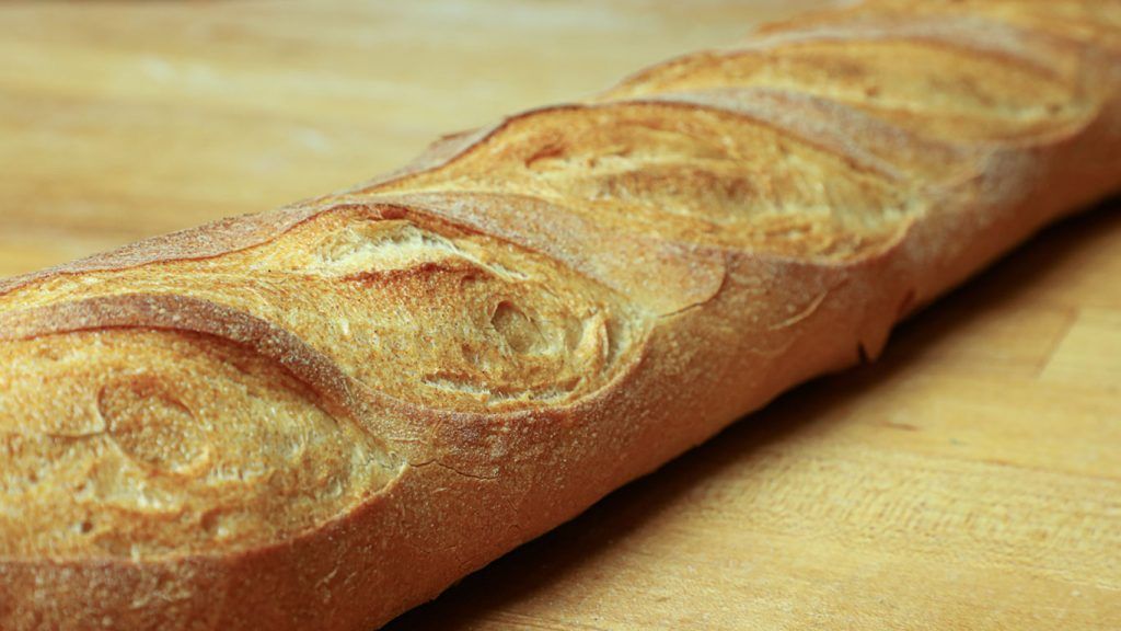 A loaf of bread is sitting on a wooden table.