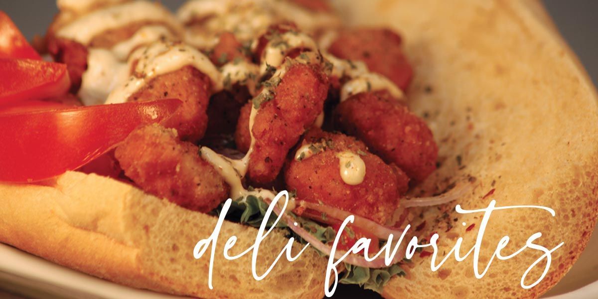 A close up of a sandwich with shrimp and tomatoes on a plate.