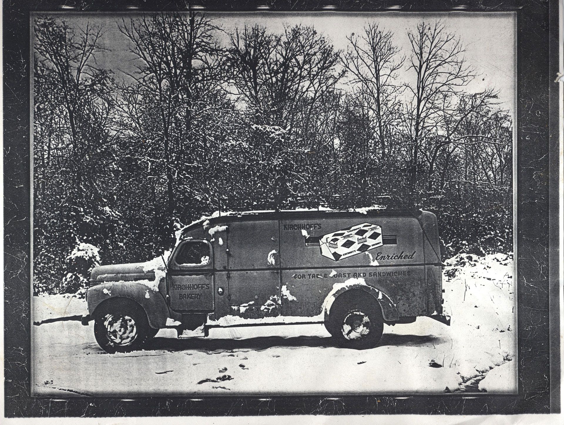 A black and white photo of a police van in the snow
