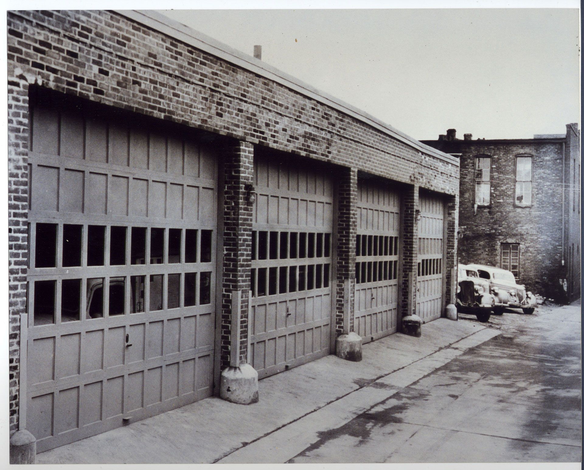 A black and white photo of a row of garage doors