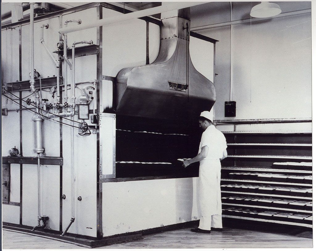 A black and white photo of a man in a kitchen