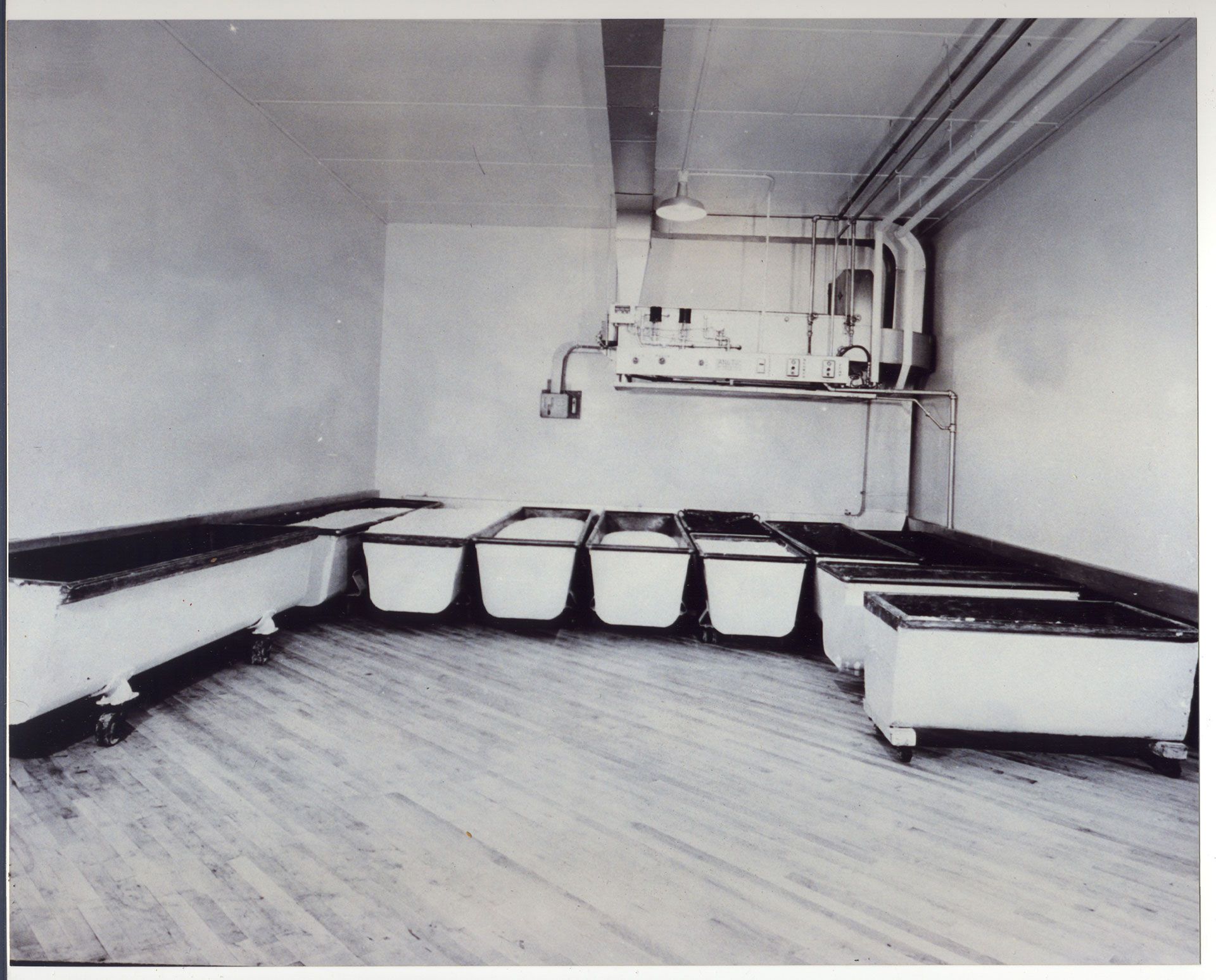 A black and white photo of a room with white bins