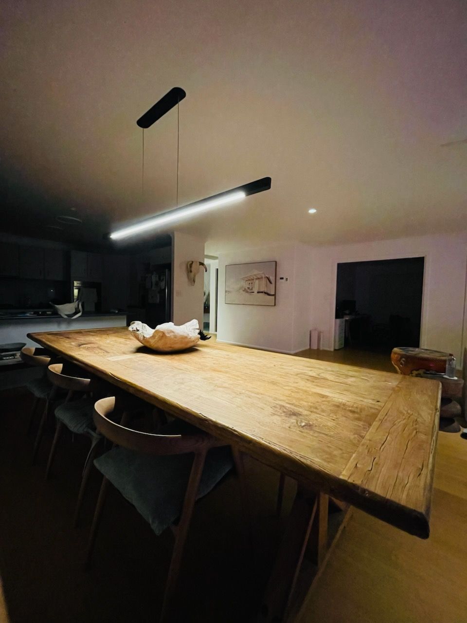Long Wooden Dining Table with Chairs, Under a Linear Light Fixture — Grant Murphy Electrical in Ocean Shores, NSW