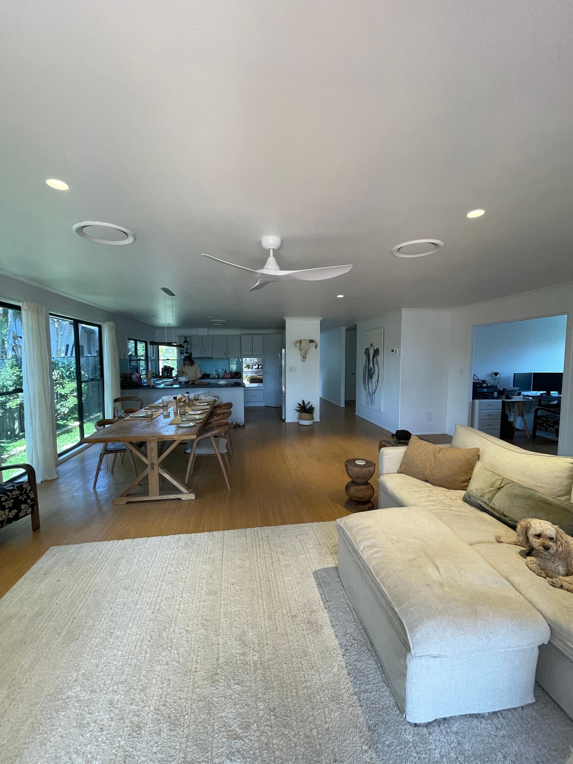 Spacious open-plan living room with light wood floors, rug, large windows, and a sectional sofa. — Grant Murphy Electrical in Kingscliff, NSW