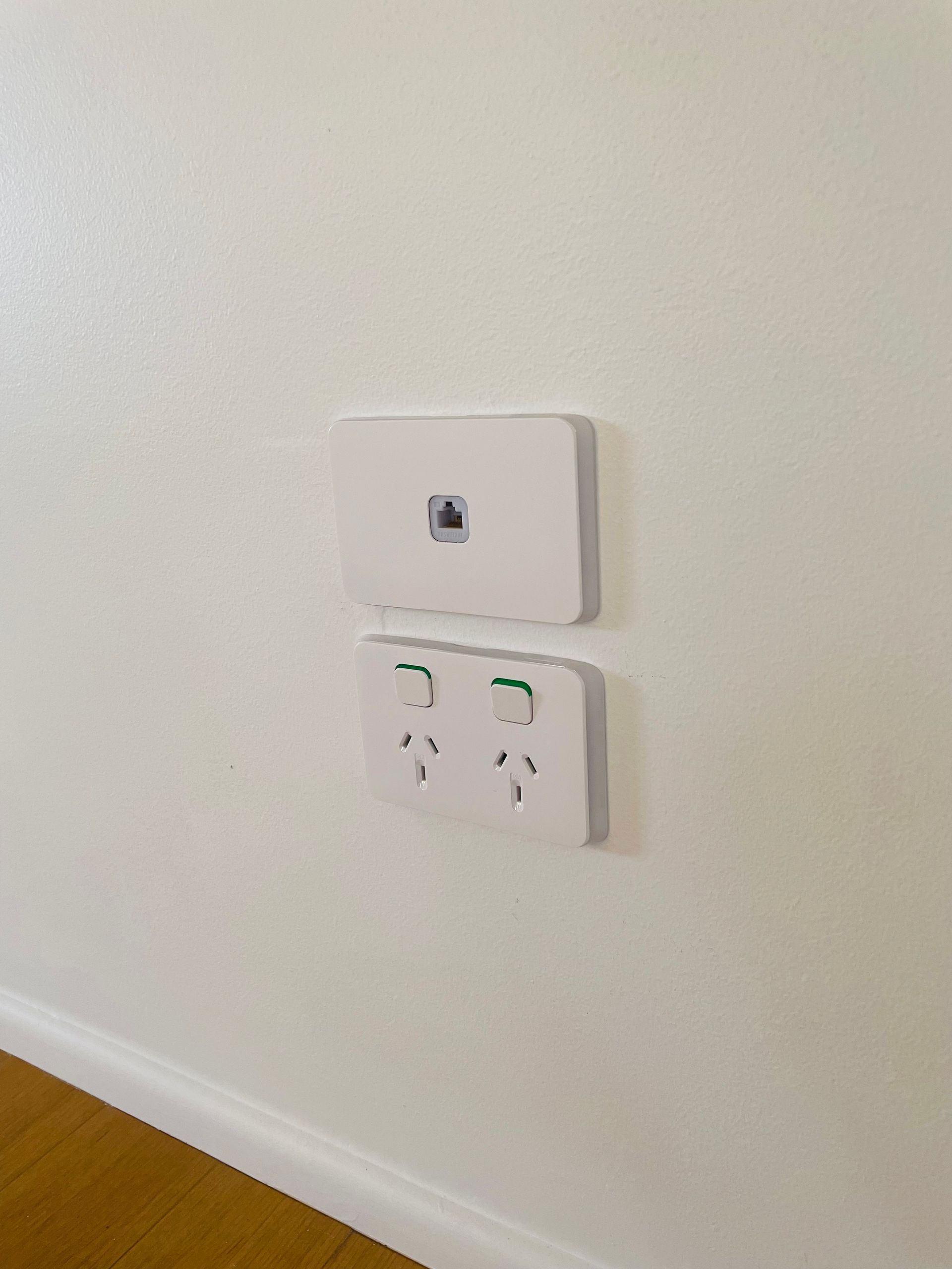 White wall with a white rectangular power outlet and a network port. — Grant Murphy Electrical in Kingscliff, NSW