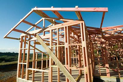 a house is being built with wooden beams and a blue sky in the background