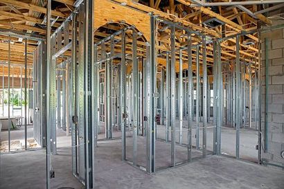 the inside of a building under construction with metal frames and wooden beams 