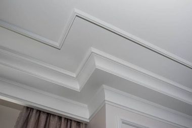 a close up of a white ceiling with molding in a living room