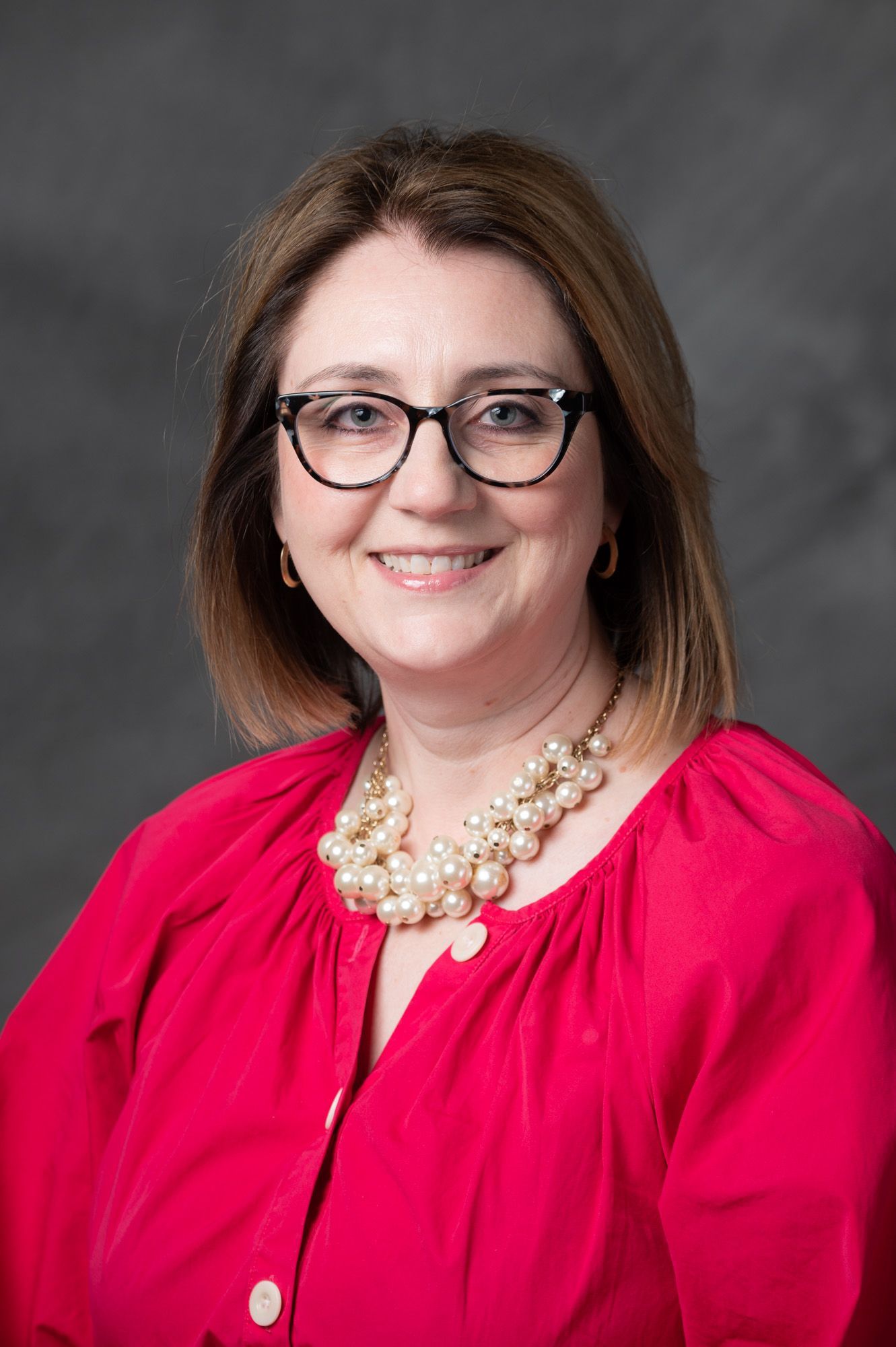 A woman in a green and white shirt is smiling