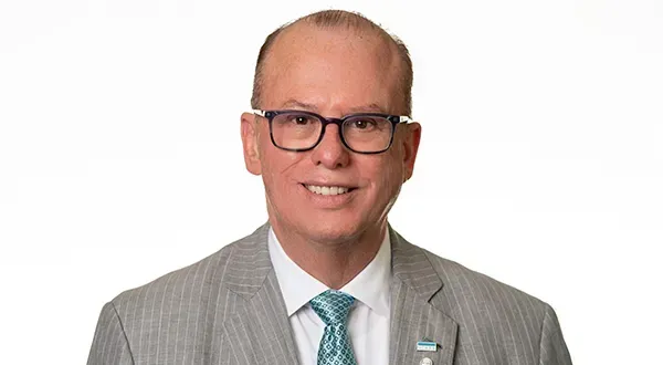 A woman with curly hair is smiling for the camera