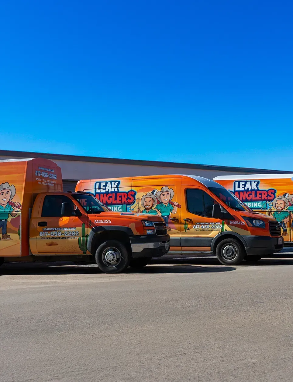 Two trucks are parked next to each other on the side of the road.