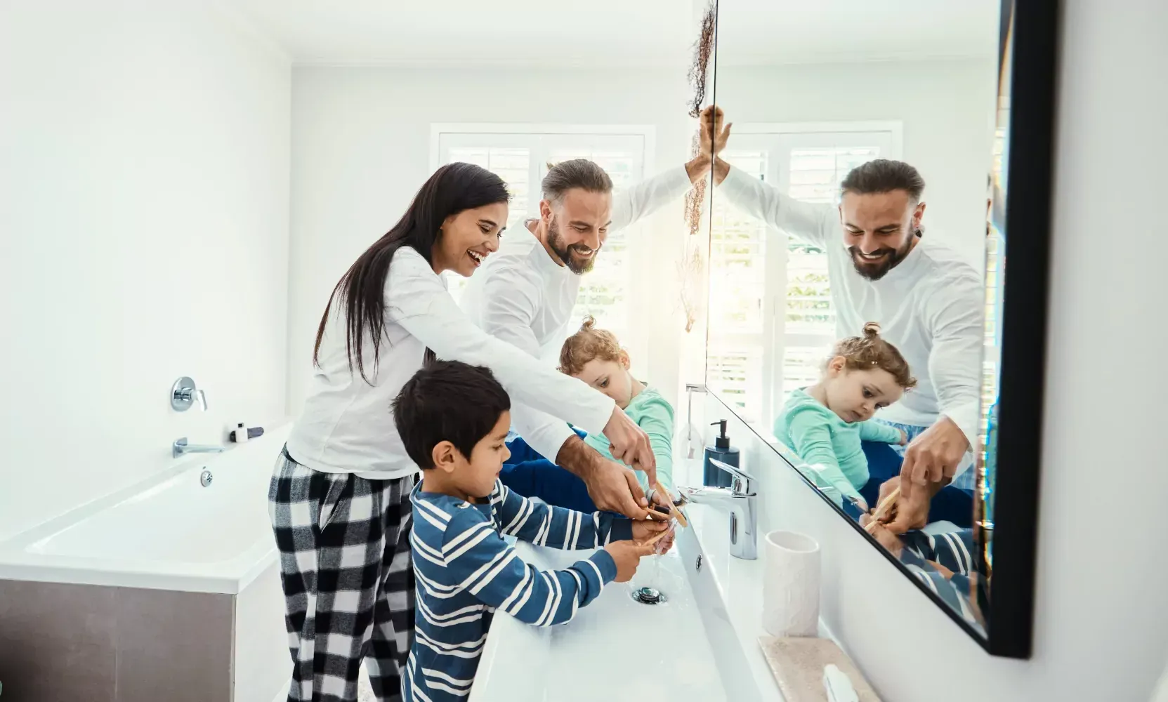 A family is brushing their teeth together in a bathroom.