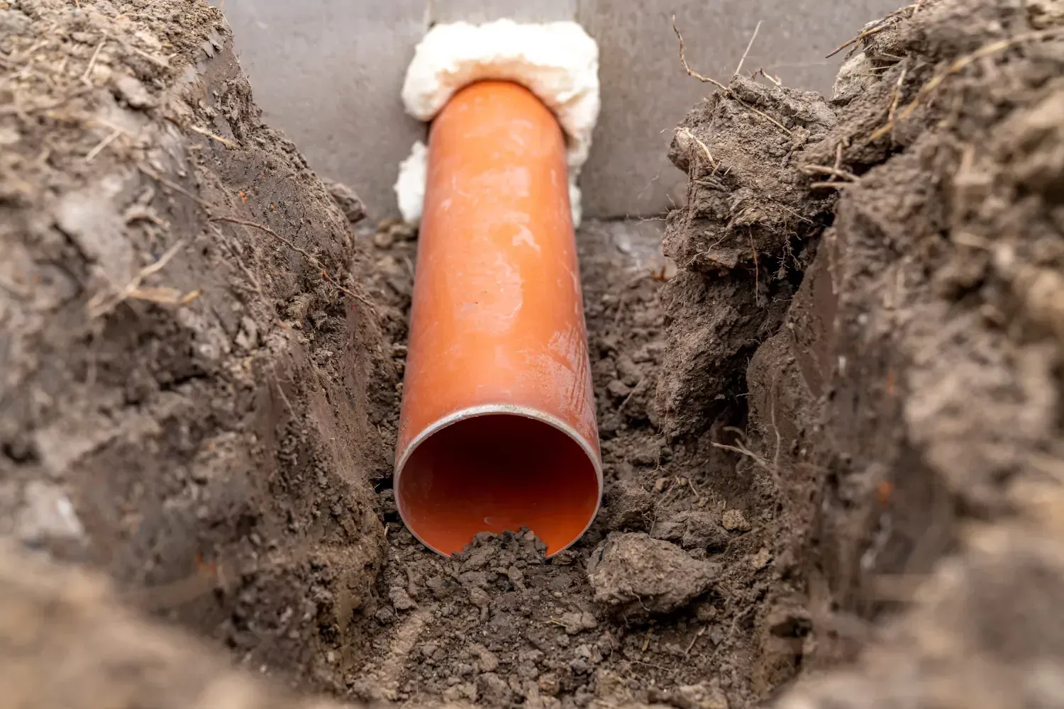 A pipe is being installed in a hole in the ground.