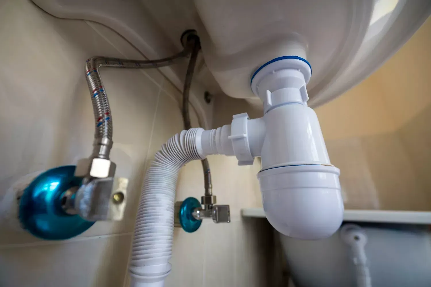 A close up of a sink drain with a hose attached to it.