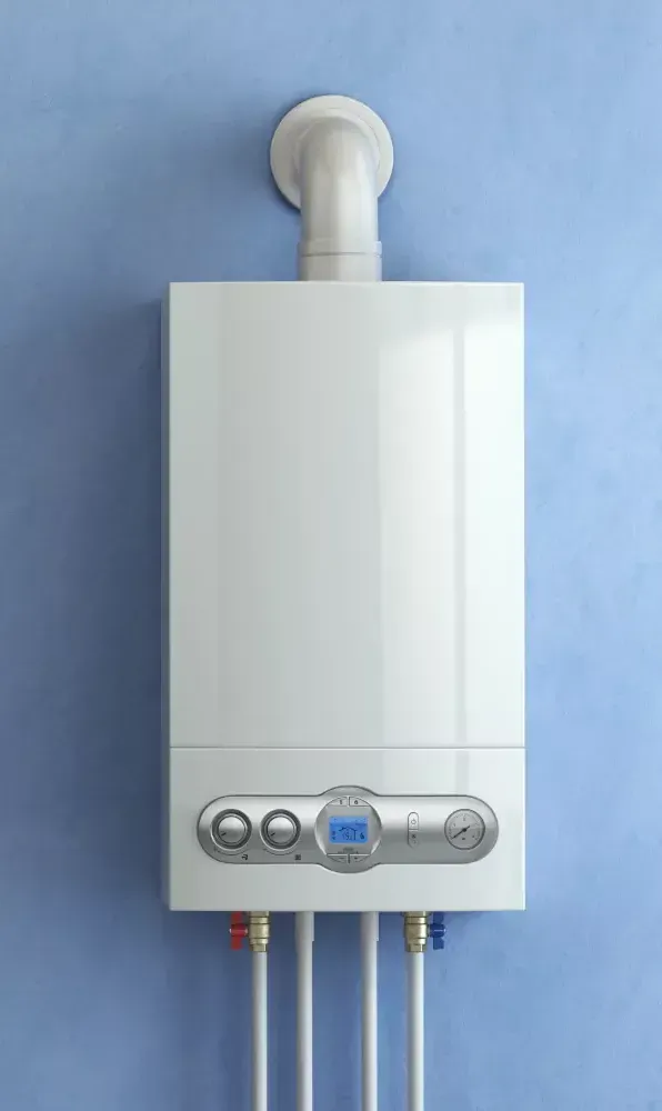 A white boiler is hanging on a blue wall.