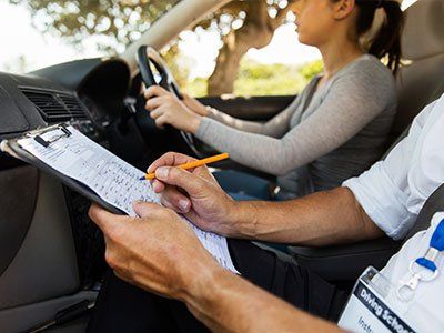 Bergen County Driving Lessons — Examiner Filling In Driver's License Road Test Form in Mine Hill, NJ