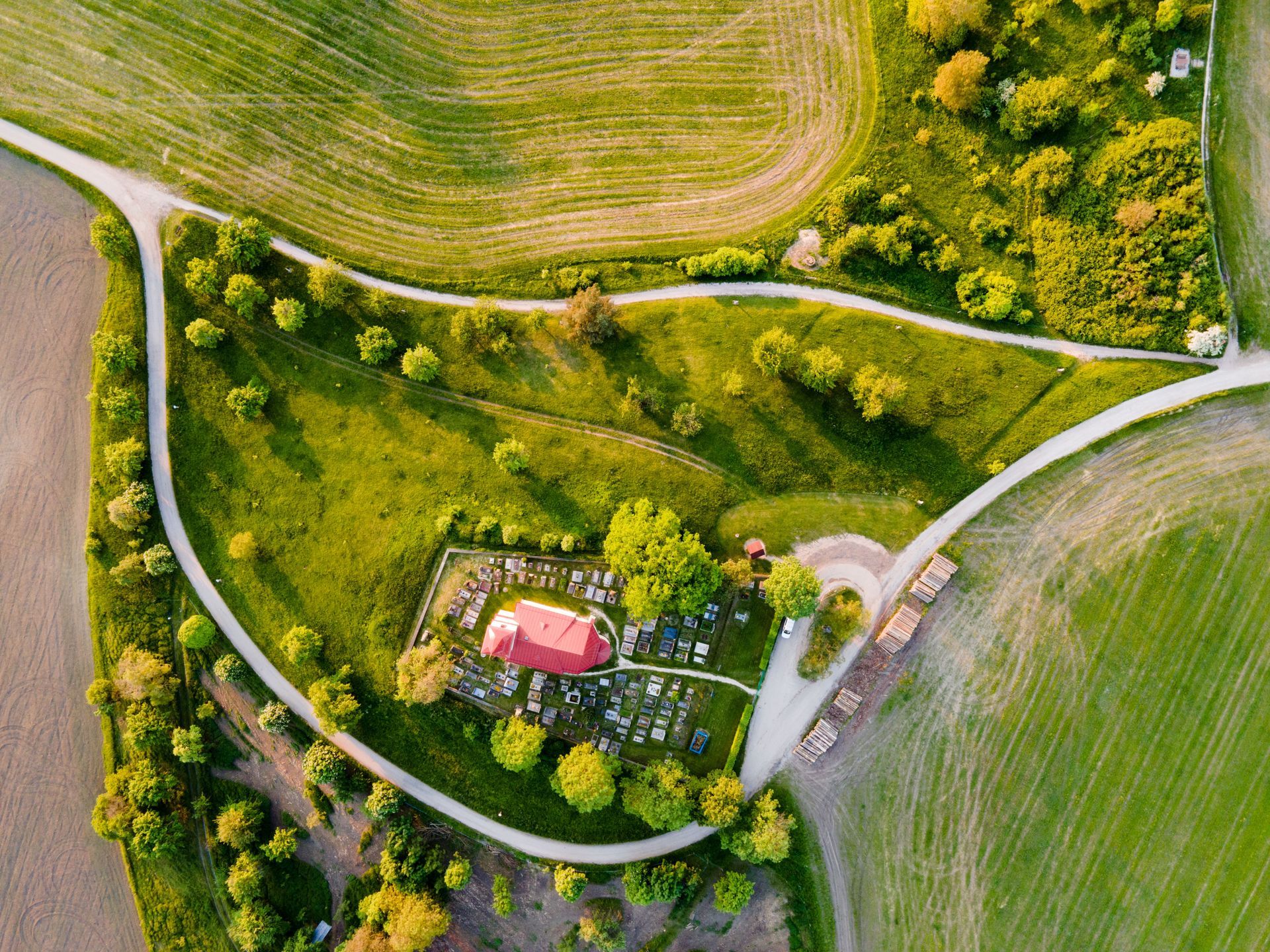 An aerial view of a farm with a red barn in the middle of a field.