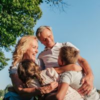A family is hugging each other in a park.