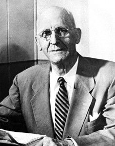 A man in a suit and tie is sitting at a table.