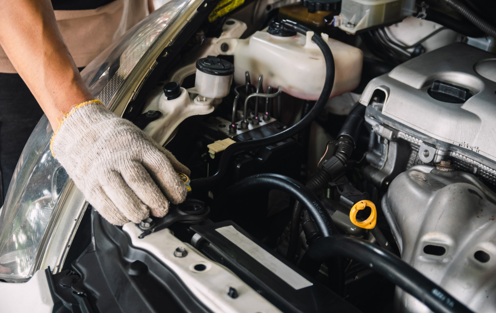 A man is working on the engine of a car.
