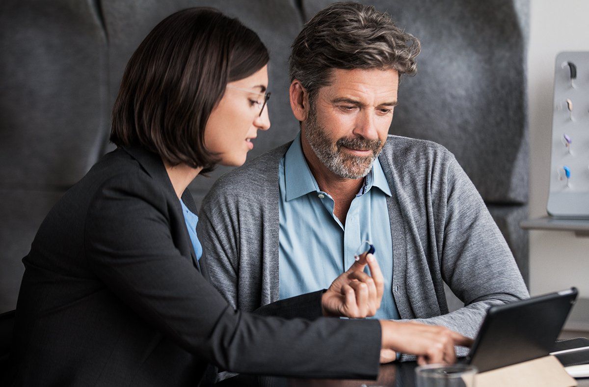 Man and woman with Oticon dispenser