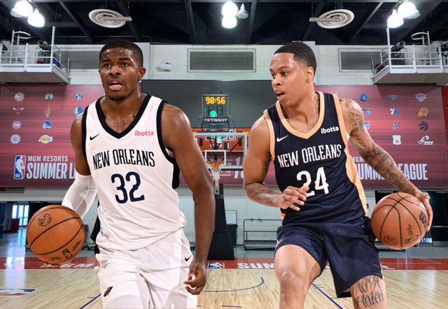 Two basketball players are playing basketball on a court.