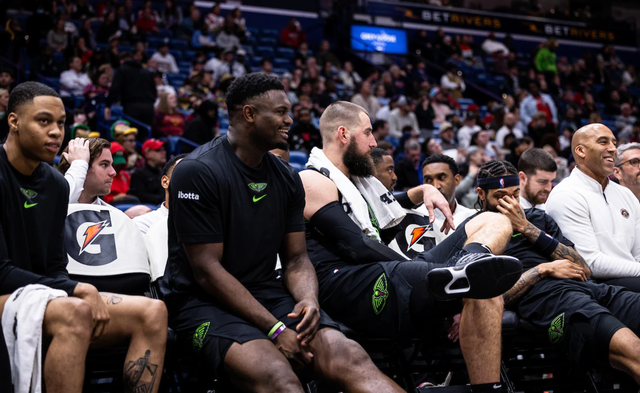 A group of basketball players are sitting on the bench during a game.