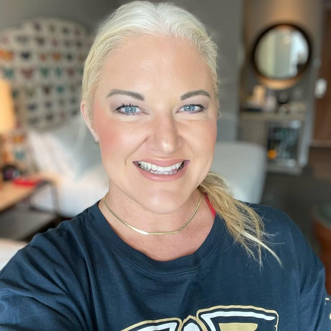 A woman in a black shirt is smiling for the camera