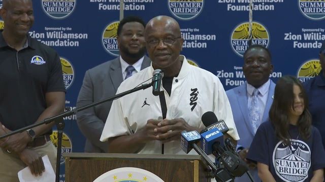 A man is standing at a podium talking into a microphone.
