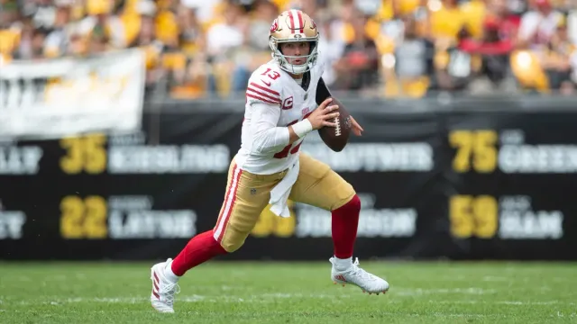 A football player is running with the ball on a field.