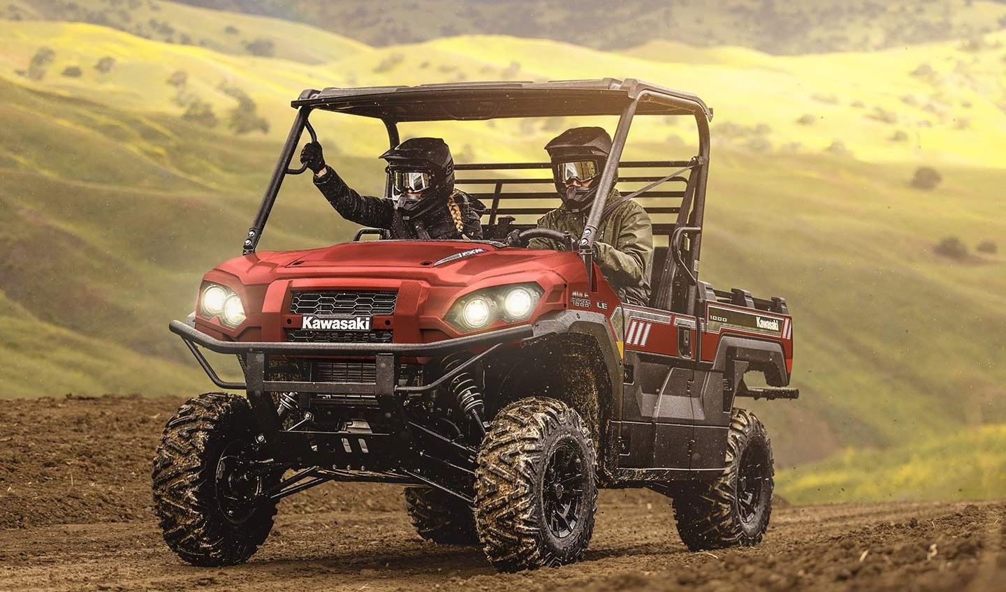 A red atv is parked on a dirt road in the desert.