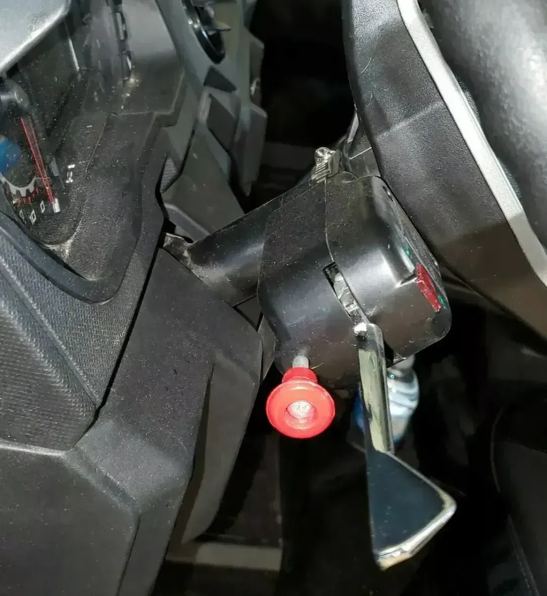 A close up of a steering wheel with a red button on it