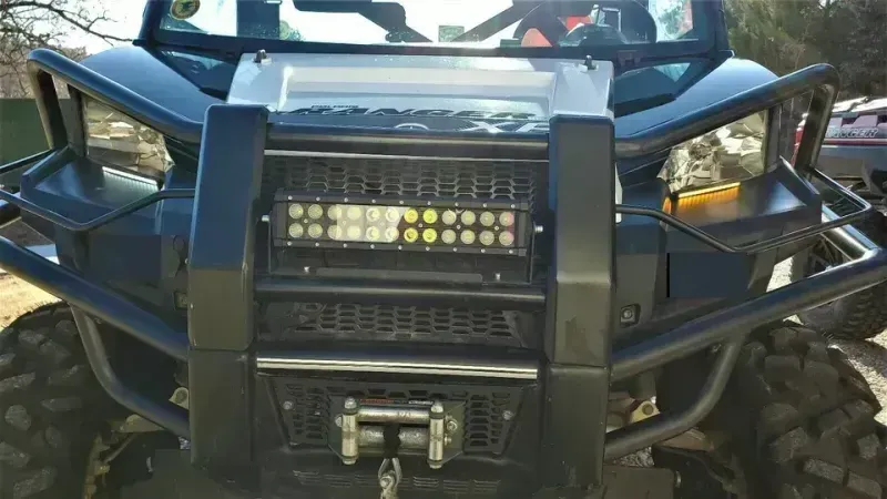 The front of a black atv with a winch attached to it.