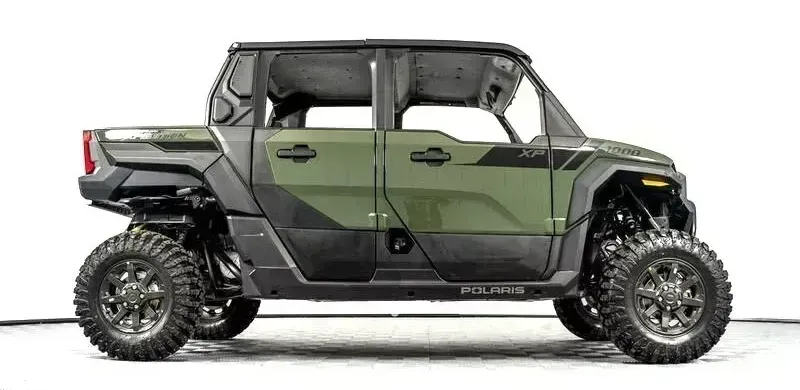 A green and black atv is parked on a white background.