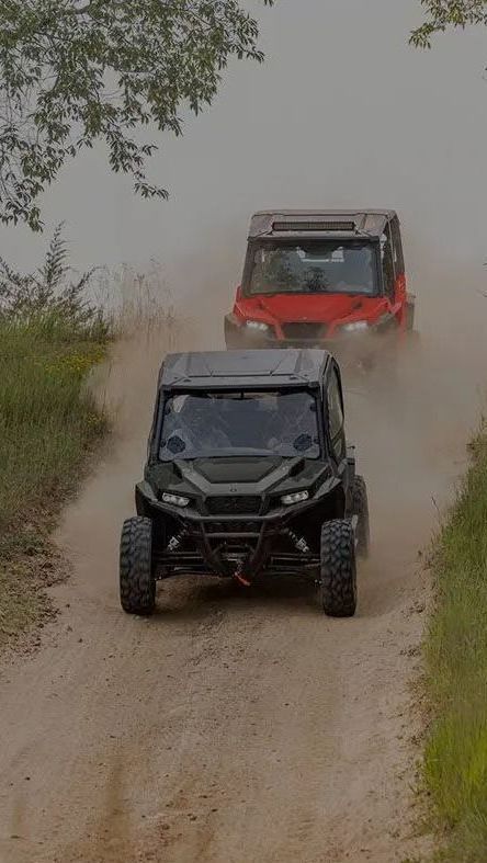 A man and a woman are standing next to a blue atv.