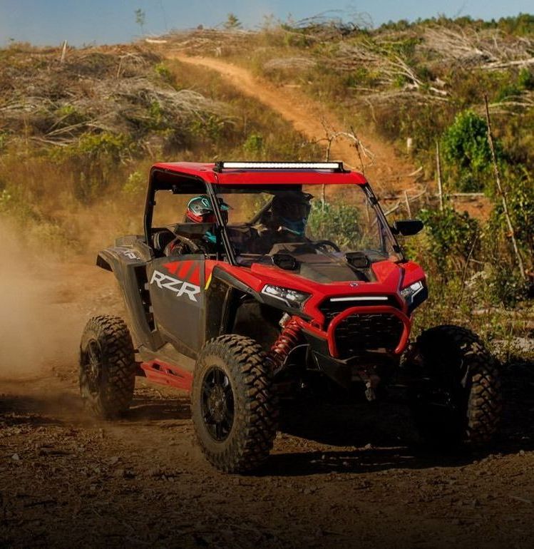 Two atvs are racing down a sand dune.