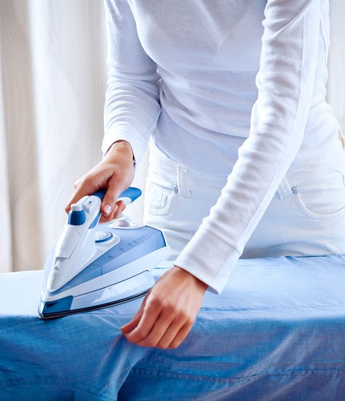 Woman ironing a blue shirt