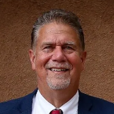 A man in a suit and tie is smiling for the camera.