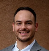 A man in a suit and tie is smiling for the camera.